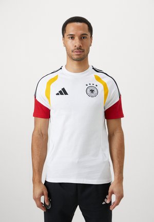 Hvit kortermet sportsskjorte med røde ermer og gule detaljer, med Adidas-logo og det tyske fotballemblemet med fire stjerner.