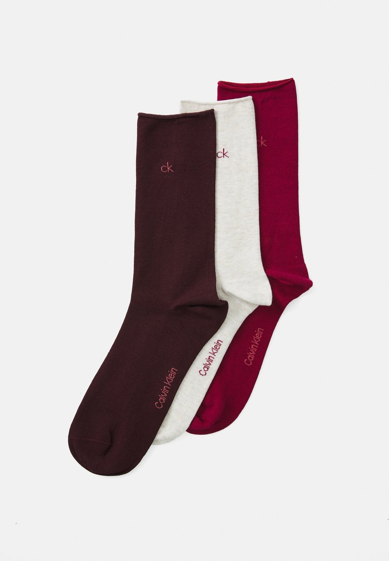 Three pairs of socks: one solid burgundy, one heather grey, and one deep red. Made of soft material, featuring "Calvin Klein" logo in contrast.