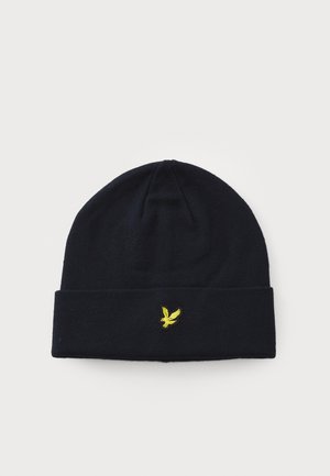 Navy knitted beanie with a rolled cuff and a yellow embroidered eagle logo on the front. Soft texture, snug fit.