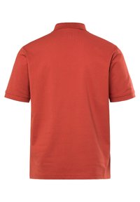 Koszulka polo z krótkim rękawem w kolorze terakotowym, z klasycznym kołnierzykiem i gładką teksturowaną tkaniną. Bez widocznych logo ani wzorów.