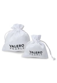 Bele pelerine iz belih tkanin s nabranimi vrhovi in z vrvicami za zapiranje. Na sprednji strani je napisan "VALERO PEARLS" v črni barvi. Predstavljeni sta dve velikosti.