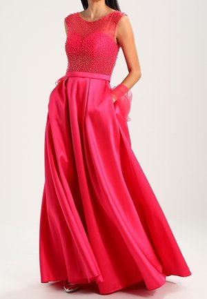 Robe longue en satin rose avec un corsage orné de perles, des manches transparentes et des poches dans une jupe évasée pour le volume et le mouvement.