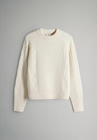Crèmekleurige trui met een gestructureerd gebreid patroon, voorzien van kabelaccenten langs de mouwen en een geribde zoom. Ronde halslijn.