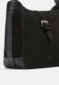 Borsa in suede nera con dettagli in pelle, dotata di chiusura a fibbia argentata e tracolla regolabile. Design semplice e strutturato.