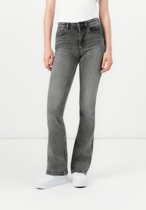 Gray denim flared jeans with a mid-rise waist, featuring front pockets and a faded wash, paired with white sneakers.