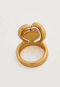 Χρυσό δαχτυλίδι με διπλή καρδιά στην κορυφή. Λείο, λαμπερό φινίρισμα με στρογγυλή μπάντα, που αναδεικνύει τις καμπυλωτές του μορφές και την κομψή υφή.