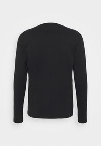 Camiseta negra de manga larga con cuello redondo, fabricada en un tejido suave. Presenta una textura lisa y un diseño sencillo, sin logotipos ni patrones visibles.