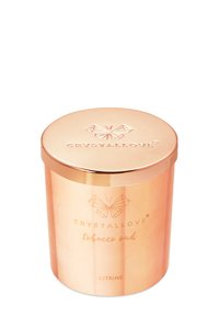 Miedziany słoik na świecę z refleksyjną powierzchnią, z wytłoczonym logo i tekstem na etykiecie, o okrągłym kształcie i dopasowanym pokrywką.