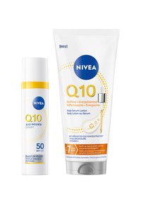 Nivea Q10 Anti-Falten Tages-UV-Fluid SPF 50 Flasche und Q10 Körperserum-Lotion Tube mit Pipette auf weißem Hintergrund.