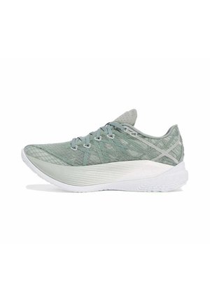 Chaussure de sport vert clair avec une tige en mesh texturé, bout rond et semelle en caoutchouc blanc. Dispose d'un système de laçage et d'une marque minimale.