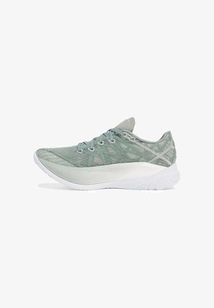 Chaussure de sport vert clair avec une tige en mesh texturé, bout rond et semelle en caoutchouc blanc. Dispose d'un système de laçage et d'une marque minimale.