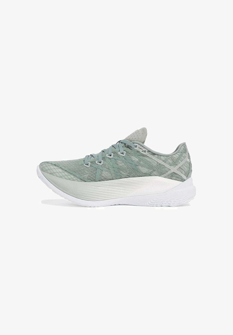 Zapatilla deportiva de color verde claro con parte superior de malla texturizada, punta redondeada y suela de goma blanca. Presenta un cierre de cordones y un branding minimalista.
