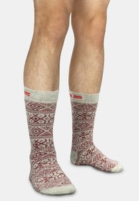 Kniestrümpfe in Beige mit einem roten geometrischen Muster. Rippbund, weiche Textur und verstärkte Spitze in passender Farbe.