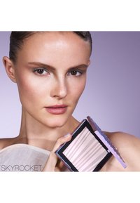 Palette di trucco compatta con un esterno argentato brillante e lavanda, caratterizzata da strisce orizzontali di tonalità morbide e chiare all'interno.