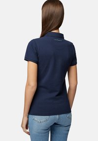 Granatowa koszulka polo z krótkimi rękawami i kołnierzykiem, z dyskretnym logo na plecach oraz gładką bawełnianą teksturą.