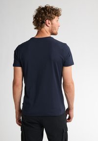 Tmavě modré bavlněné tričko s krátkým rukávem a kulatým výstřihem, s hladkou texturou. Zobrazeno zezadu s minimálními detaily.