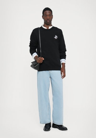 Black sweatshirt with a crew neck and embroidered design, paired with light blue wide-leg jeans and black leather shoes. Small crossbody bag.