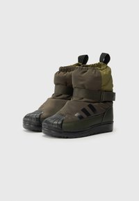Botas de inverno verdes e pretas com design acolchoado, solas de borracha texturizada, punhos elásticos e fecho de cinta. Apresenta três riscas pretas.