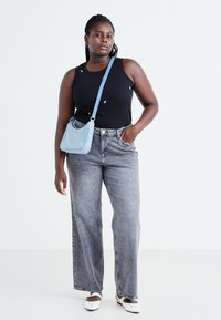 Black tank top with small embroidery, gray wide-leg jeans, light blue crossbody bag, and white slip-on shoes. Simple, casual outfit.