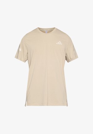 Camiseta beige de manga corta hecha de tejido suave. Presenta un logo blanco en el pecho y detalles angulados en las mangas. Bajo recto con aberturas laterales.