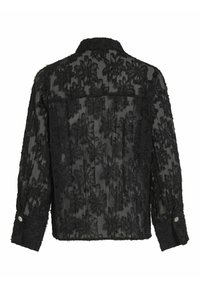 Veste en dentelle noire avec motifs floraux, texture transparente et poignets boutonnés. Le design comprend un col structuré et des plis au dos.