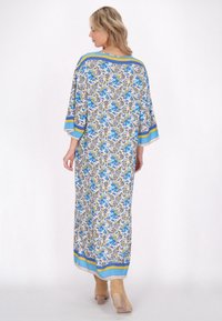 Kaftan lungo a fantasia in tessuto leggero presenta un motivo floreale blu e giallo, maniche ampie e accenti a righe contrastanti all'orlo.