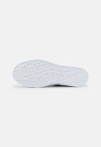 Weiße Sneaker-Sohle mit einem geometrischen Profil, das rechteckige und Kreuzformen für besseren Halt aufweist, sowie dem eingravierten Markennamen "Hilfiger" nahe der Ferse.