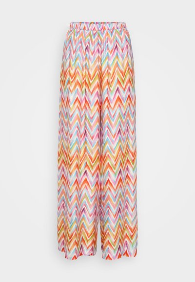 Pantalones palazzo con un patrón zigzagueante colorido y una cintura elástica. Hechos de una tela ligera en tonos de rosa, naranja y azul.