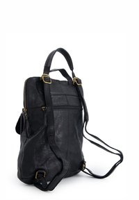 Black leather backpack with adjustable straps, brass hardware, front zipper pocket, smooth texture, and defined stitching details.