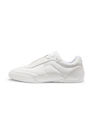 Witte leren sneaker met laag profiel, subtiele stiksels, vetersluiting en rubberen zool, zijwaarts getoond op een witte achtergrond.
