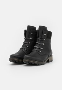 Bottines noires avec tige en cuir, lacées à l'avant, avec des ferrures en argent et une semelle en caoutchouc texturé. Dotées d'un talon bloc et de coutures contrastantes.