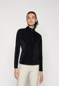 Schwarze Samt-Jacke mit Reißverschluss, vertikalen Streifen, hohem Kragen und langen Ärmeln. Besitzt ein tailliertes Design, eine weiche Textur und ein dezentes Logo-Detail.