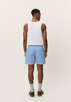 Sinised ja valged triibulised lühikesed püksid elastse vöökoha, kahe tagatasku ja lõdva istuvusega, kantud valge topi ja hallide sokkidega.