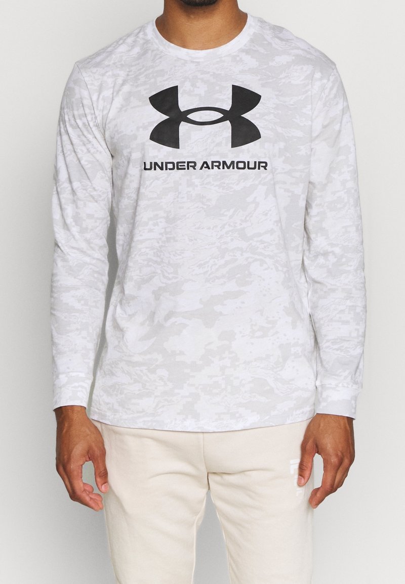 Langärmliges graues Camouflage-Shirt aus leichtem Stoff, mit einem auffälligen schwarzen Under Armour-Logo auf der Brust.