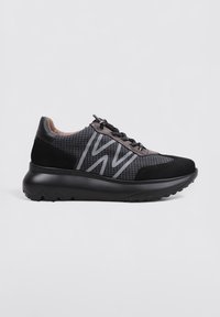 Scarpe sportive nere con tomaia in rete a motivo a griglia, accenti in suede e una suola spessa e texturizzata. Dettaglio del logo riflettente sul lato.