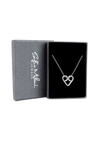 Silverhjärtans halsband på en delikat kedja, presenterad i en texturerad grå smyckeslåda med svart inredning.