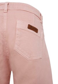 Lichtroze denim en katoenblend broek met een achterzak voorzien van een label van bruin leer. Close-upweergave benadrukt de stikseldetails.