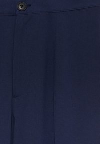 Tissu bleu marine avec un bouton noir et un détail de poche cousu sur une paire de pantalons sur mesure.