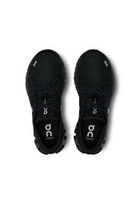 Chaussures de sport noires avec un dessus en mesh respirant, bout rond et accents de logo blancs contrastants ; semelle à texture anti-dérapante. Les lacets sont noirs.