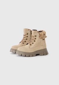 Bottines en suede beige avec doublure en fourrure douce, fermeture à lacets à l'avant et zip sur le côté. Semelle en caoutchouc gris épais avec un profond relief pour une meilleure adhérence.