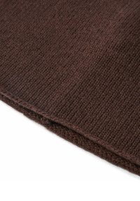Tessuto marrone lavorato a maglia con motivo a coste testurizzato, caratterizzato da un bordo piegato e da un filato morbido e spesso.