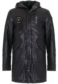 Zwarte leren parka-jack met een capuchon, voorzien van meerdere voorzakken, een ronde patch en drukknopen/sluitingen. Textuur oppervlak.