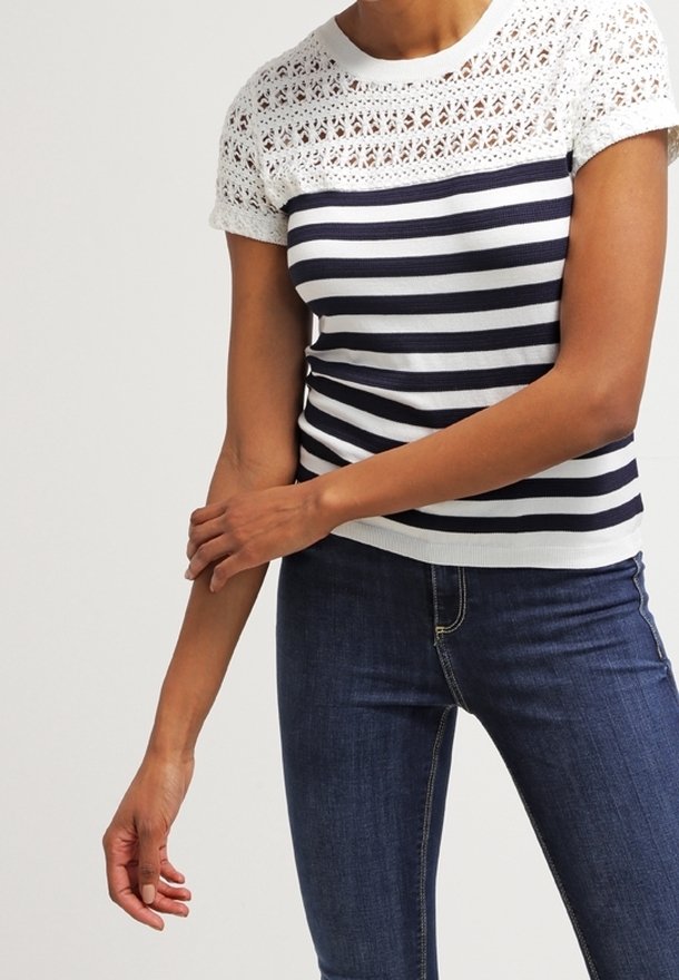Top de punto a rayas azul marino y blanco con canesú de encaje. Mangas cortas y diseño ajustado, con un patrón de encaje abierto y texturizado en los hombros.