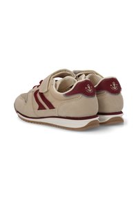 Zapatillas beige con acentos burdeos, material de ante, cuello acolchado y cierre de gancho y bucle. Presentan una media suela blanca y suela texturizada.