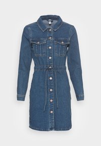 Jeanimekko pitkällä hihalla, nappilista edessä, kaksi rintataskua, istuva vyötärö nyöreillä ja polven pituinen helma, tummansininen pesu.