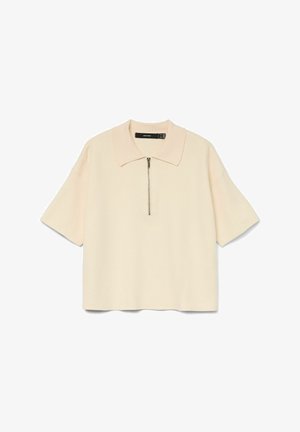 Haut à manches courtes avec col en tissu beige doux, doté d'une fermeture éclair à l'avant. Design simple avec une coupe décontractée et un minimum de détails.