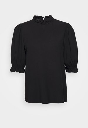 Blouse noire avec manches courtes bouffantes et poignets volantés, col montant volanté, présentée sur un fond blanc uni.