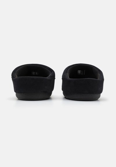 Zwarte suède instapschoenen met een gestructureerde bovenkant, ronde achterkant en rubberen zolen. Minimalistisch ontwerp zonder zichtbare hardware of accenten.