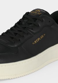 Μαύρο δερμάτινο αθλητικό παπούτσι με μαύρα κορδόνια, λευκή σόλα και χρυσή επιγραφή "REPLAY Est 1981" στο πλάι και στη γλώσσα.