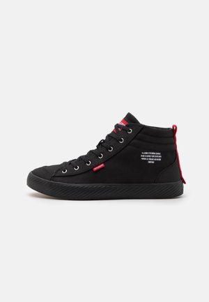 Baskets montantes noires avec lacets noirs, languette en tissu rouge et tirette au talon, avec texte blanc sur le panneau latéral extérieur.